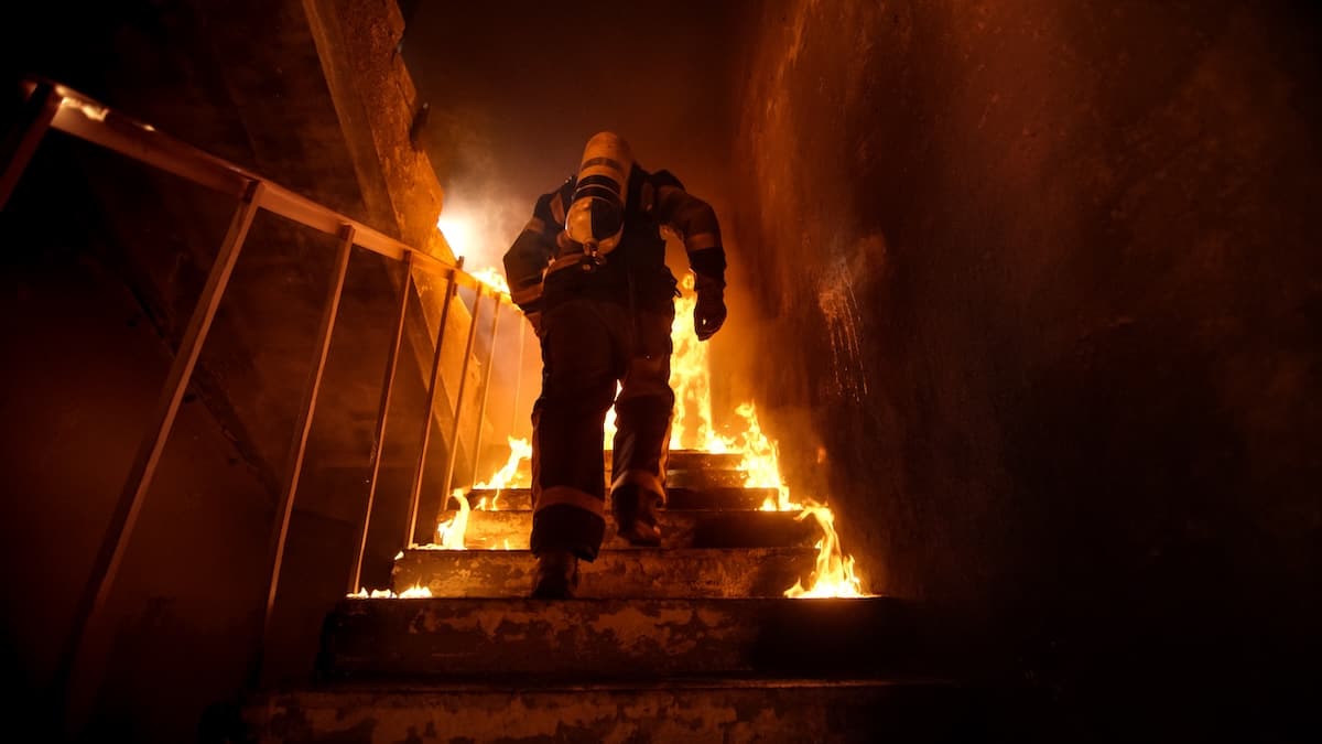Brave Firefighter Going Up The Stairs In Burning Building Brave Firefighter Going Up The Stairs In Burning Building